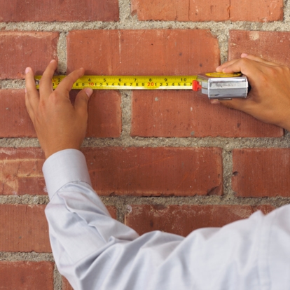 Measuring tape on brick wall