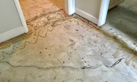 A close-up of a cracked concrete wall or floor before repair.