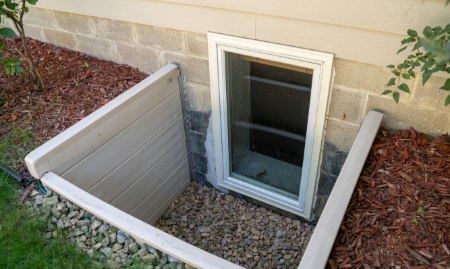 A basement with an installed egress window with sunshine coming through.